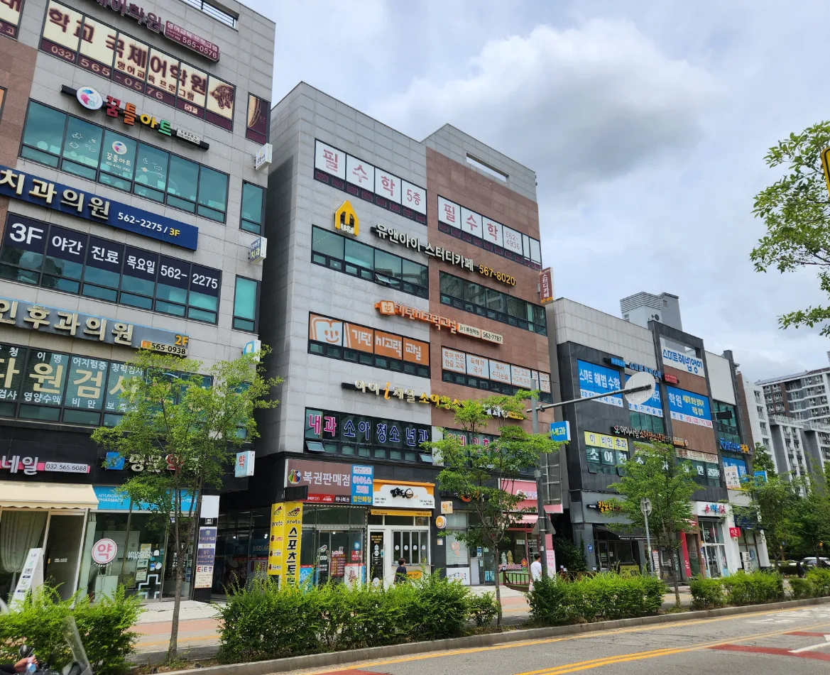 가정동 607-6 측면 – 필수학·스터디카페·소아청소년과 간판이 걸린 5층 상가건물과 인근 메디컬 상가