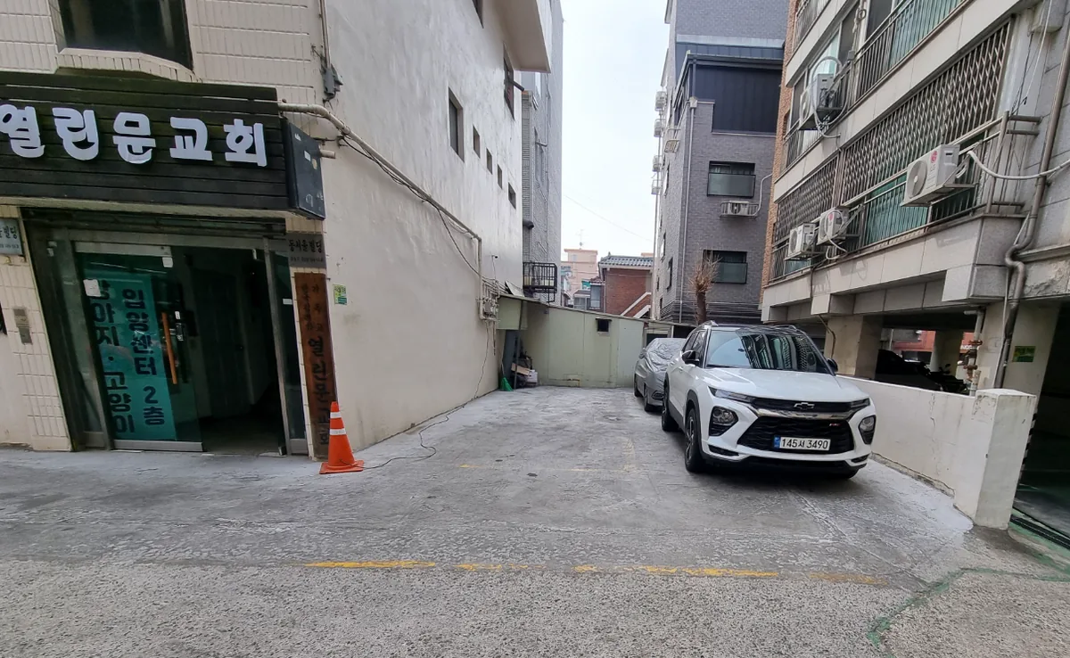 길동 104-14 건물 뒤편 자주식 주차 공간과 지하1층 교회 출입구
