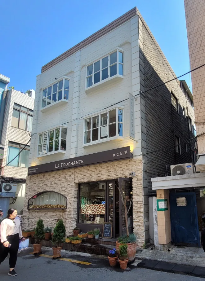 망원동 411-8 건물 측면 – 흰색 벽돌 외벽과 1층 베이커리 쇼윈도