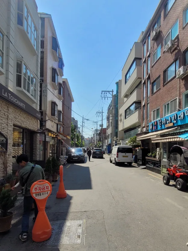망원동 411-8 건물 앞 이면도로 – 양쪽으로 상가가 늘어선 망원시장 방면 골목