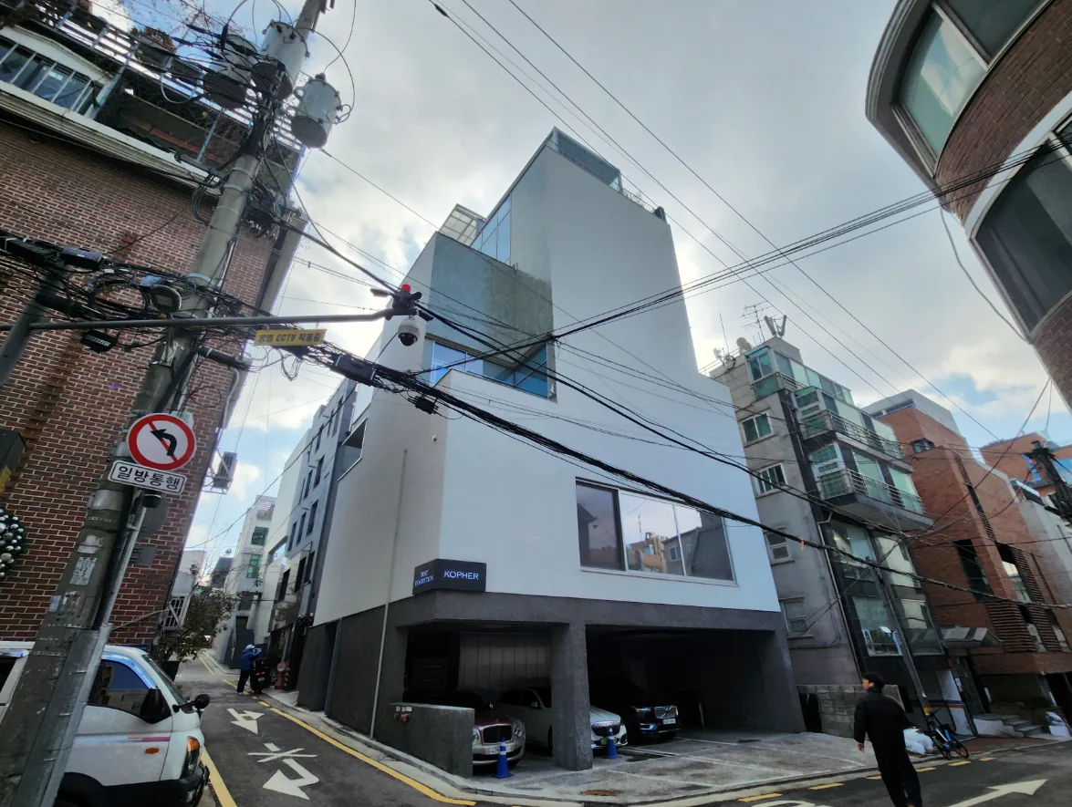 강남구 논현동 73-3 코너 전경 – 1층을 필로티로 연 백색 마감의 지상 5층 신축 사옥