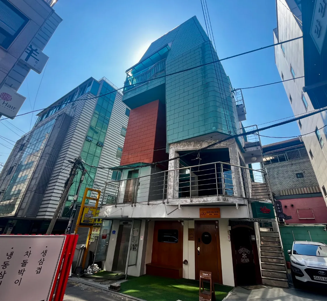 마포구 상수동 317-3 전경 – 색면으로 마감한 지상 6층 건물 정면과 1층 테라스