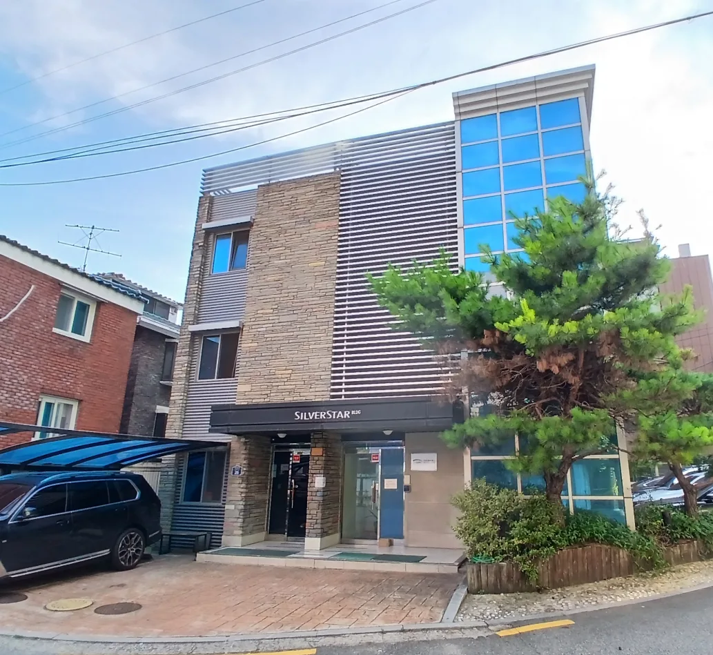 서교동 377-18 정면 – 외장을 정비한 3층 건물의 출입구와 앞마당 주차 공간