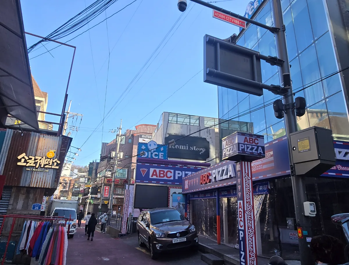 서교동 408-6 앞 골목 – 음식점과 의류 매장이 늘어선 홍대 주차장길 보행 동선