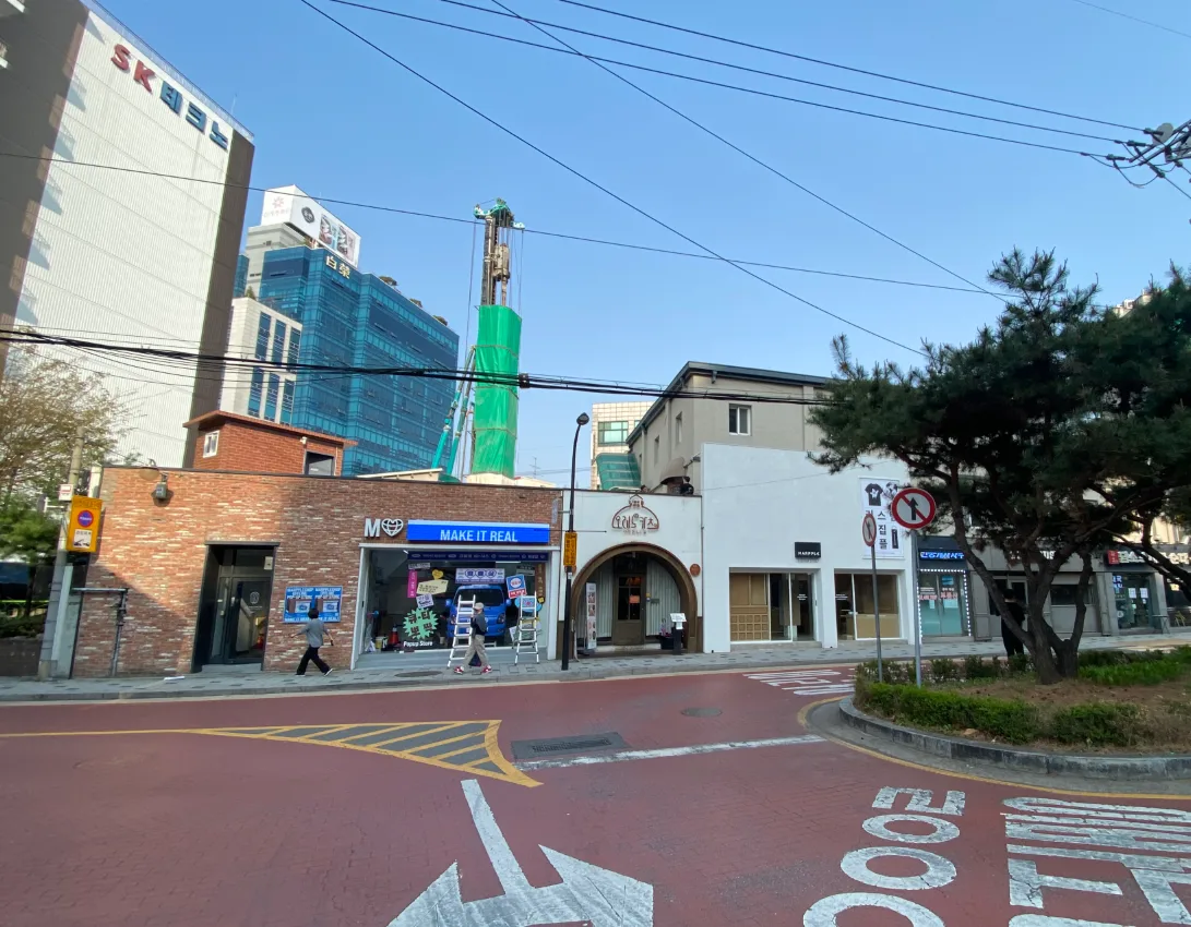 성동구 성수동1가 16-8 일대 – 연무장길 진입로의 저층 벽돌 상가와 붉은 포장 도로
